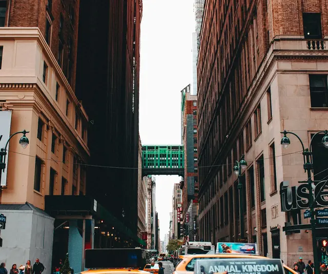 taxi car between brown buildings during day time